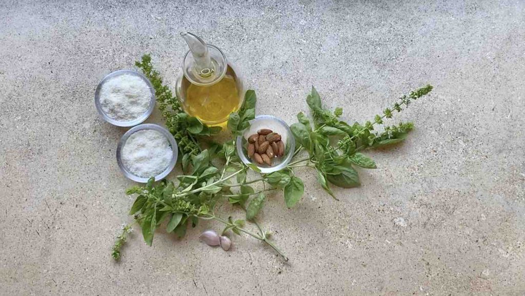Ingredienti per fare il pesto al basilico e mandorle: olio, pecorino, grana, mandorle, basilico e aglio.