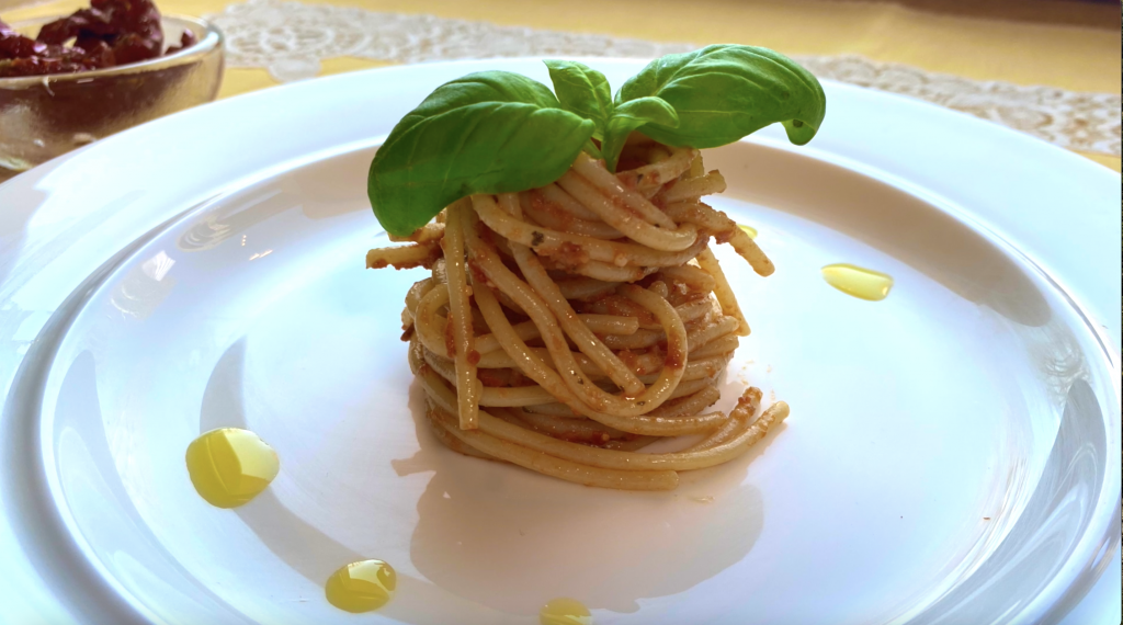 Spaghetti con pesto di pomodori secchi e pinoli